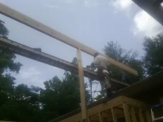 Carpenter setting a ridge beam over a new addition frame — Ice Dam Removal by Roofing Brothers in Wolfe City