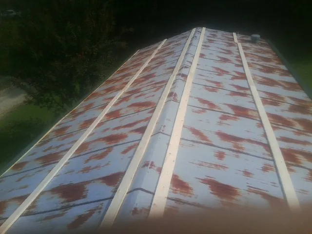 Rusted metal roof panels with new wood purlins before replacement — Storm Damage Roof Repair in Wolfe City by Roofing Brothers