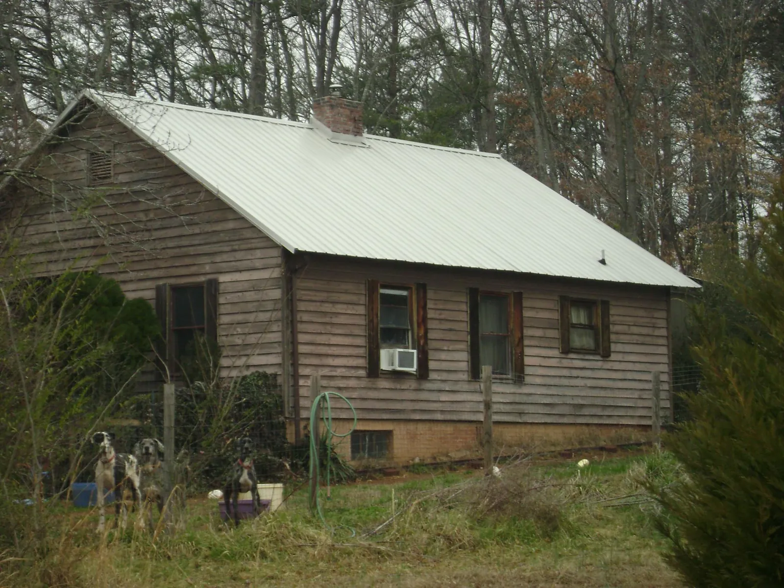 White metal roof on an old wood sided farmhouse, from a Metal Roof Installation job in Wolfe City